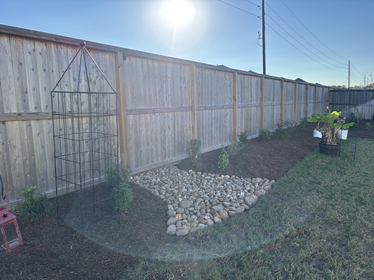 Wooden privacy fence installation with garden bed